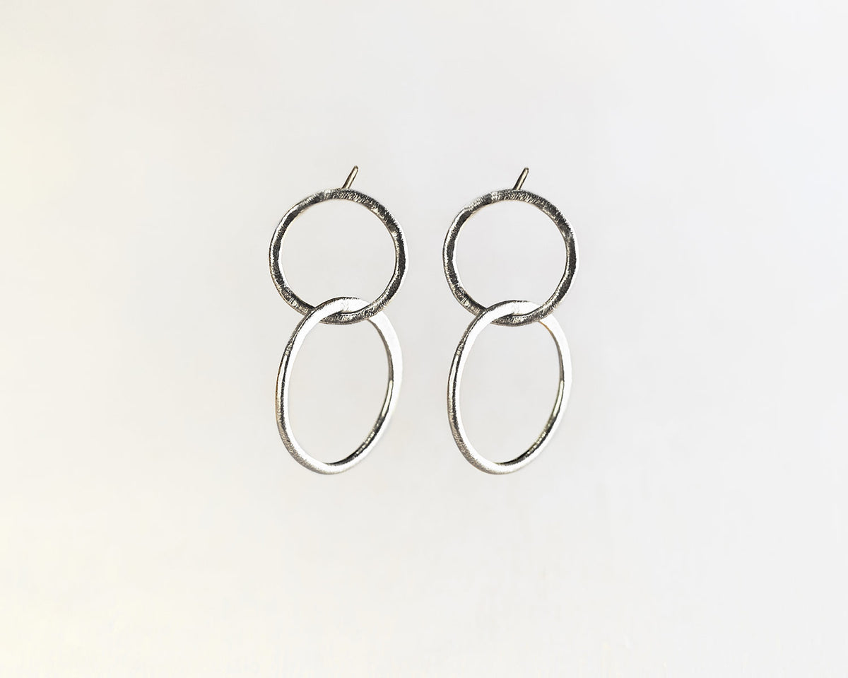 Primer plano de los pendientes plateados compuestos por dos piezas circulares de Isla Vurma