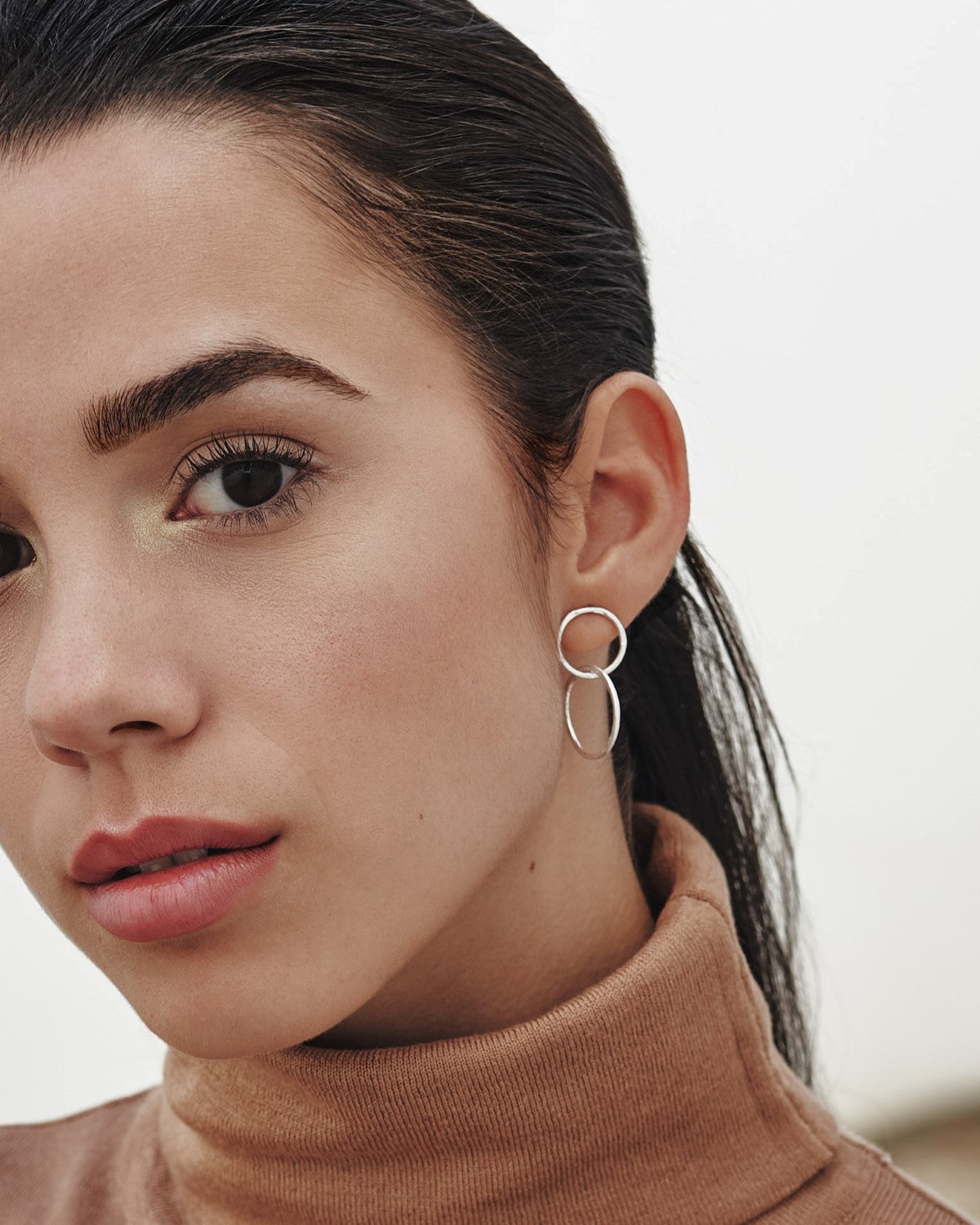 Modelo con los pendientes plateados formados por dos circulos de Isla Vurma