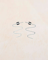 Primer plano de los pendientes plateados con forma de zigzag