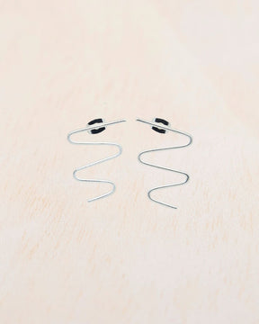 Primer plano de los pendientes plateados con forma de zigzag