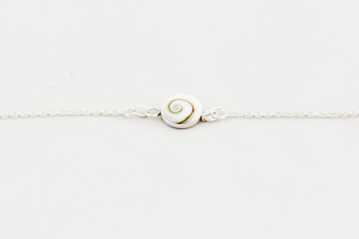 Pulsera de plata con concha de Santa Lucía centrada sobre fondo blanco