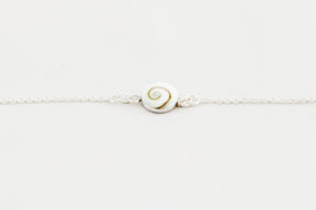 Pulsera de plata con concha de Santa Lucía centrada sobre fondo blanco