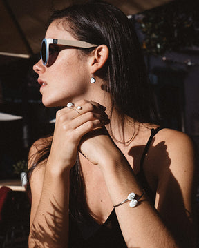 Modelo de perfil luciendo pulsera de plata de ley 925 con piedra de Santa Lucía