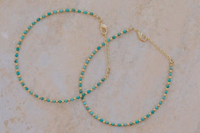 Primer plano de un conjunto de dos pulseras con cuentas facetadas de piedra semipreciosa en Aqua Calcedonia y bañadas en Oro de 18 quilates con cierre de gancho bañado en oro de 18 quilates