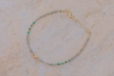 Primer plano una pulsera con cuentas facetadas de piedra semipreciosa en Labradorita, Aqua Calcedonia y bañadas en Oro de 18 quilates