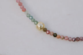 Primer plano una pulsera con cuentas facetadas de piedra semipreciosa en Turmalina Multicolor y bañadas en Oro de 18 quilates con cierre de gancho bañado en oro de 18 quilates