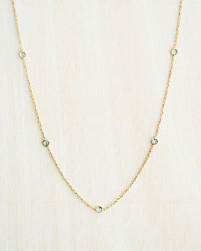 Collar bañado en oro de 18k con piedras de Aqua Calcedonia sobre fondo claro de Isla Vurma 