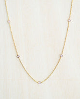 Collar bañado en oro de 18k con piedras de Cuarzo Rosa sobre fondo claro de Isla Vurma 