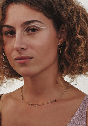 Mujer con cabello rizado lleva el collar con piedras semipreciosas de  Lapislázuli, Cuarzo Rosa, Aqua Calcedonia, Amatista Verde y cadena dorada de Isla Vurma