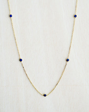 Collar bañado en oro de 18k con piedras de Lapislázuli sobre fondo claro de Isla Vurma 