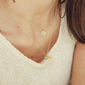 Primer plano del collar acabado en oro 18k con piedra semipreciosa aqua calcedonia y otro en Piedra de Luna de Isla Vurma