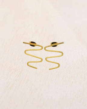 Primer plano de los pendientes dorados con forma ondulada