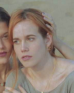 Primer plano de la modelo luciendo los pendientes dorados con diseño en forma de zigzag